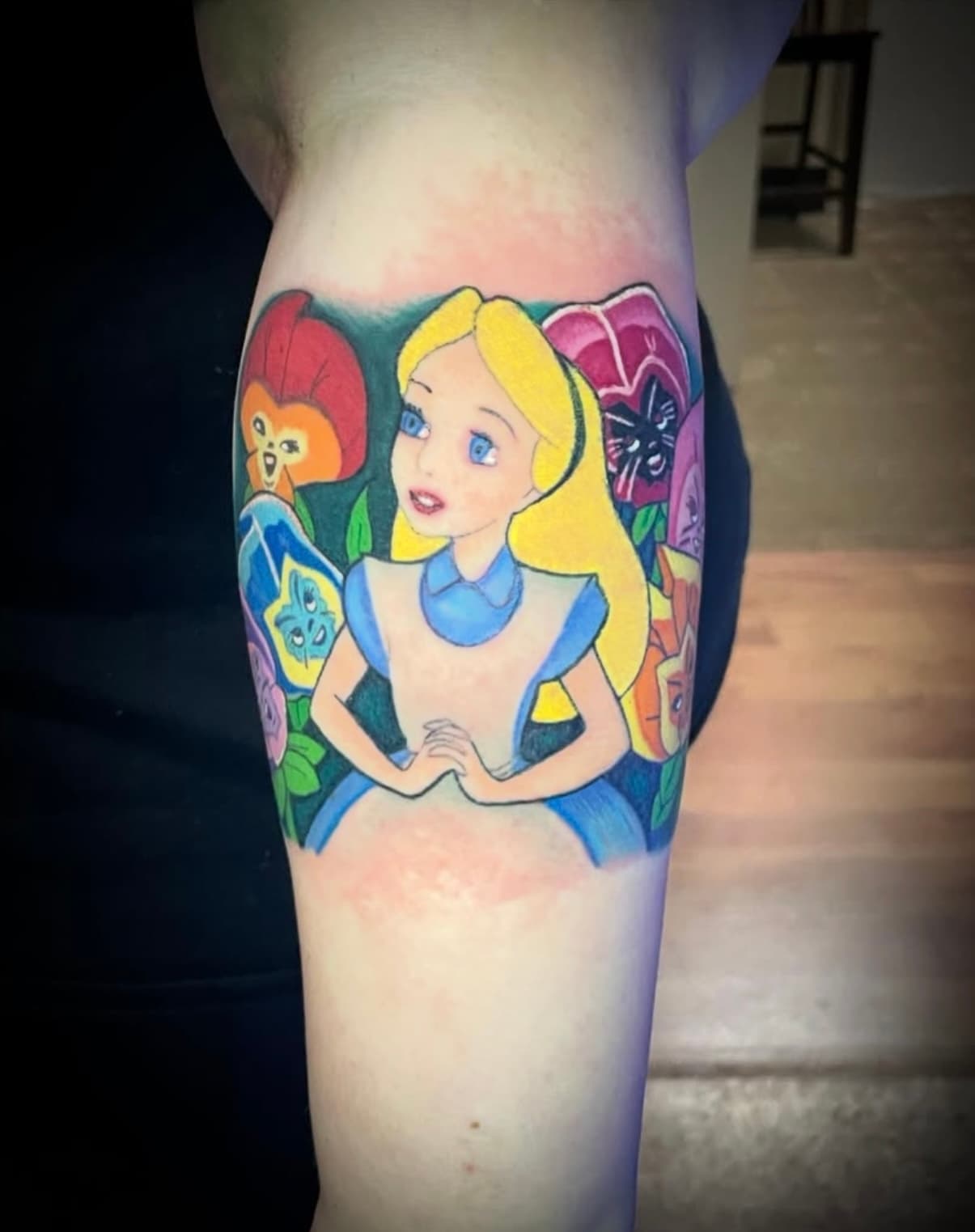 Colorful Alice in Wonderland character tattoo on forearm