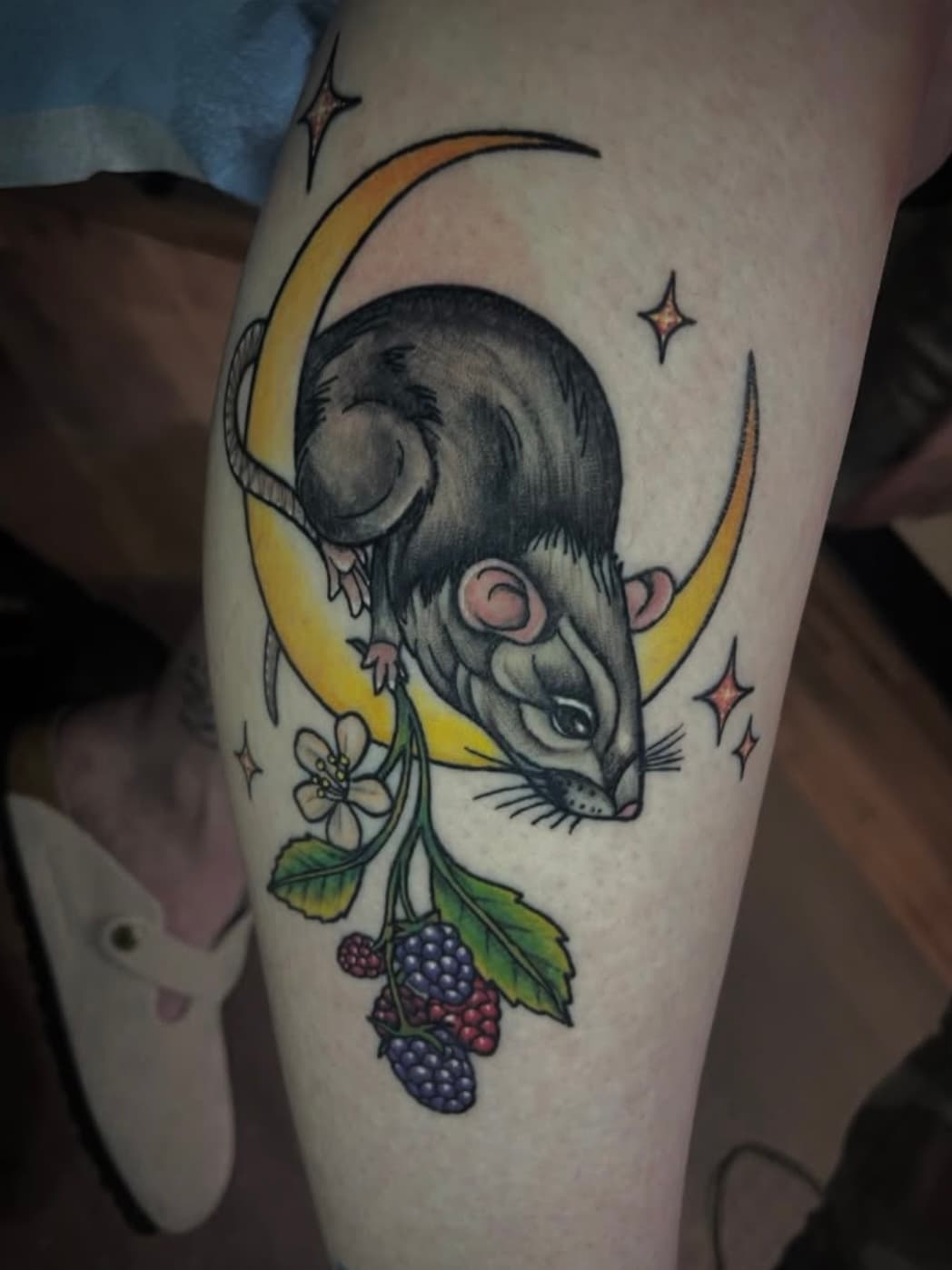 Black and gray rat on crescent moon tattoo with berries and flowers